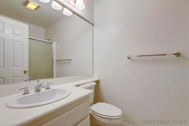 a bathroom with a toilet a sink a mirror and vanity