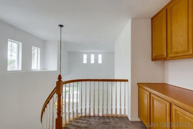 a view of a hallway to a bedroom with windows