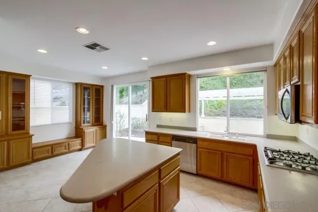 a large kitchen with kitchen island a large window in it