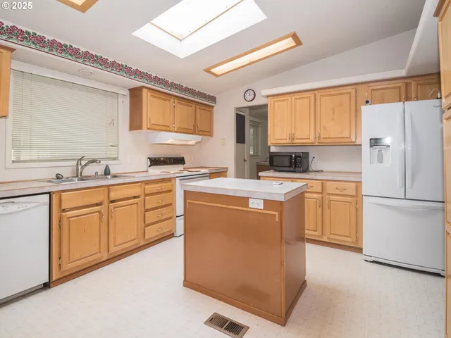 a kitchen with granite countertop a sink and white cabinets