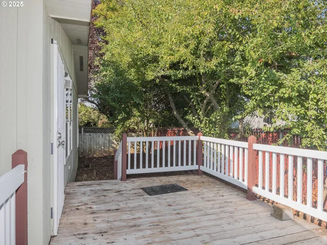 a view of balcony with wooden floor and fence