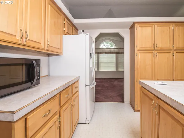 a kitchen with a sink a stove a refrigerator a center island and a window