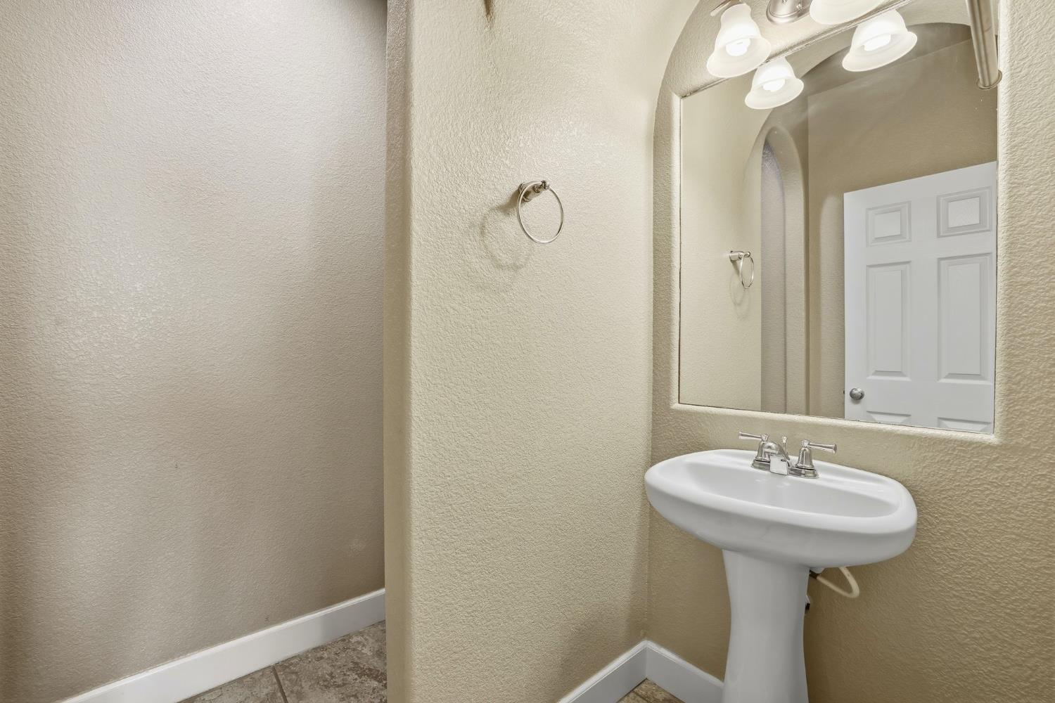 1730 Tasca Lane Manteca, CA 95337 - Photo 16 of 83 a bathroom with a sink a light fixture and a mirror