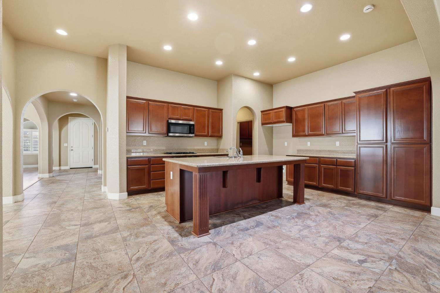 1730 Tasca Lane Manteca, CA 95337 - Photo 19 of 83 a kitchen with stainless steel appliances granite countertop a stove refrigerator sink and cabinets