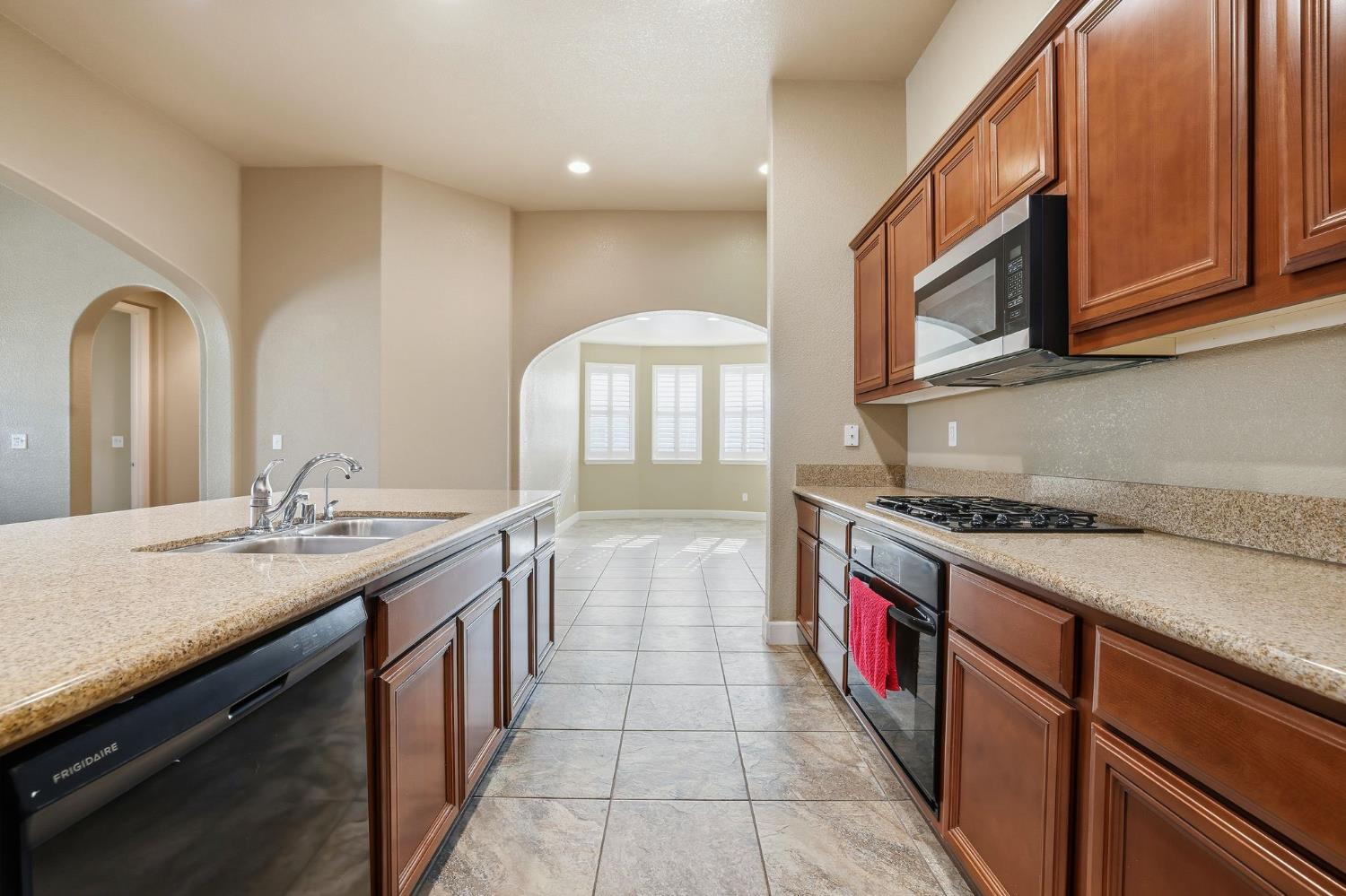 1730 Tasca Lane Manteca, CA 95337 - Photo 21 of 83 a kitchen with stainless steel appliances granite countertop a stove and a sink