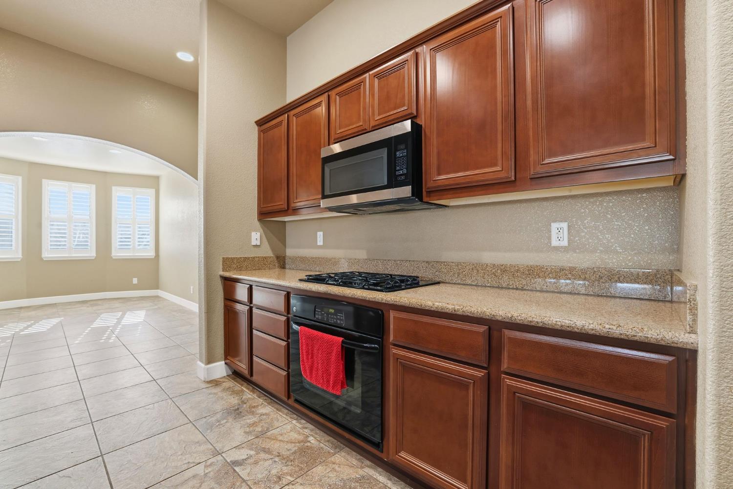 1730 Tasca Lane Manteca, CA 95337 - Photo 23 of 83 a kitchen with stainless steel appliances granite countertop a stove microwave and cabinets