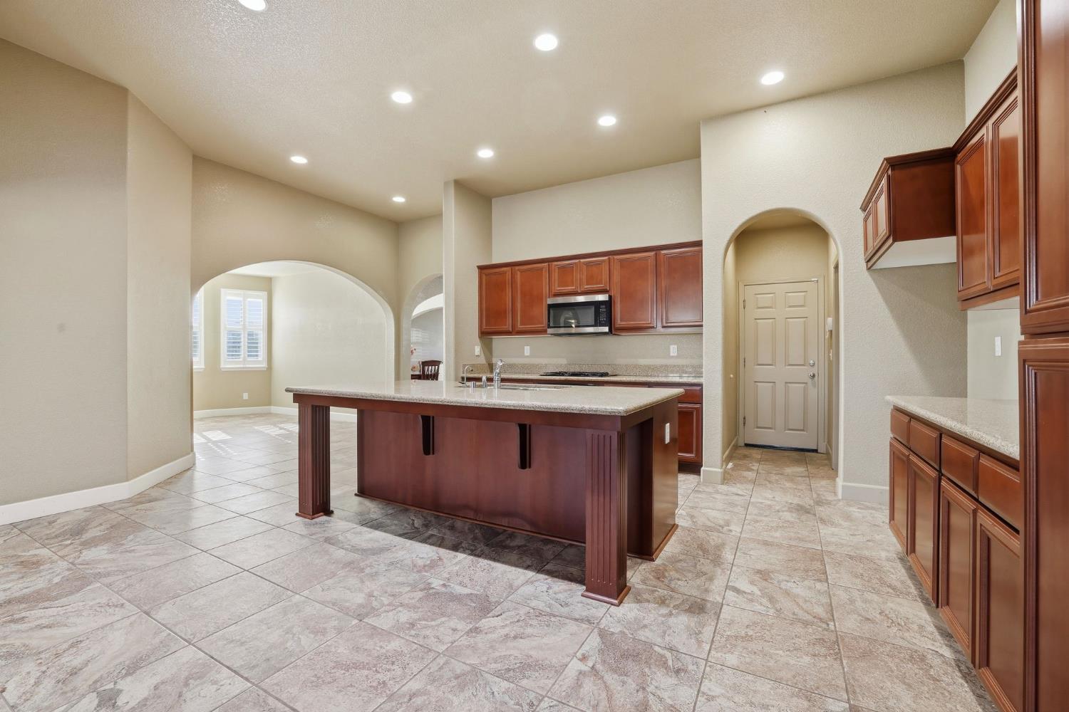 1730 Tasca Lane Manteca, CA 95337 - Photo 25 of 83 a kitchen with stainless steel appliances granite countertop a stove a sink and a microwave