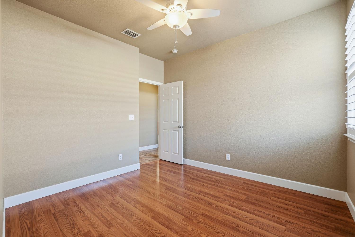 1730 Tasca Lane Manteca, CA 95337 - Photo 39 of 83 wooden floor in an empty room with a window