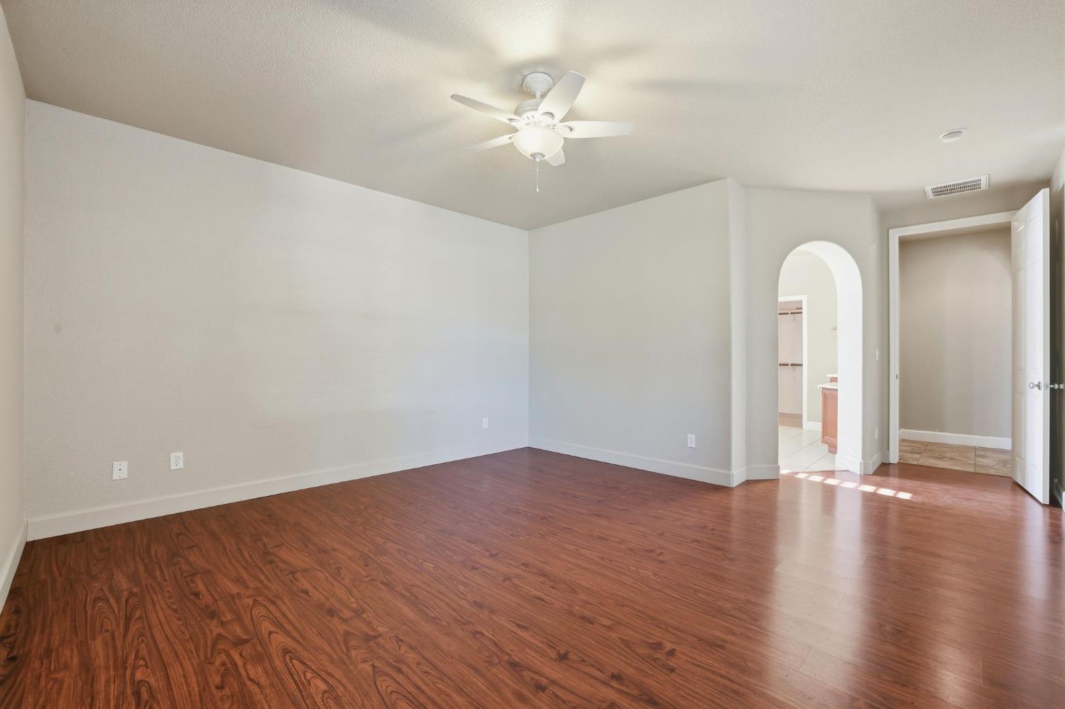 1730 Tasca Lane Manteca, CA 95337 - Photo 47 of 83 an empty room with wooden floor and ceiling fan