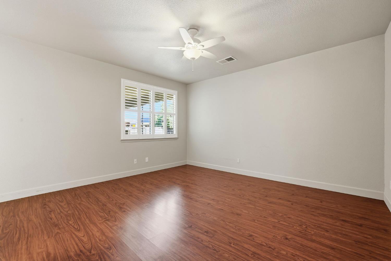 1730 Tasca Lane Manteca, CA 95337 - Photo 48 of 83 an empty room with wooden floor and windows