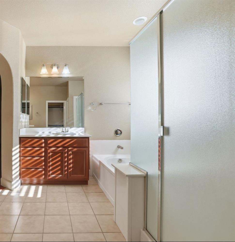 1730 Tasca Lane Manteca, CA 95337 - Photo 52 of 83 a bathroom with a sink a mirror and a bathtub