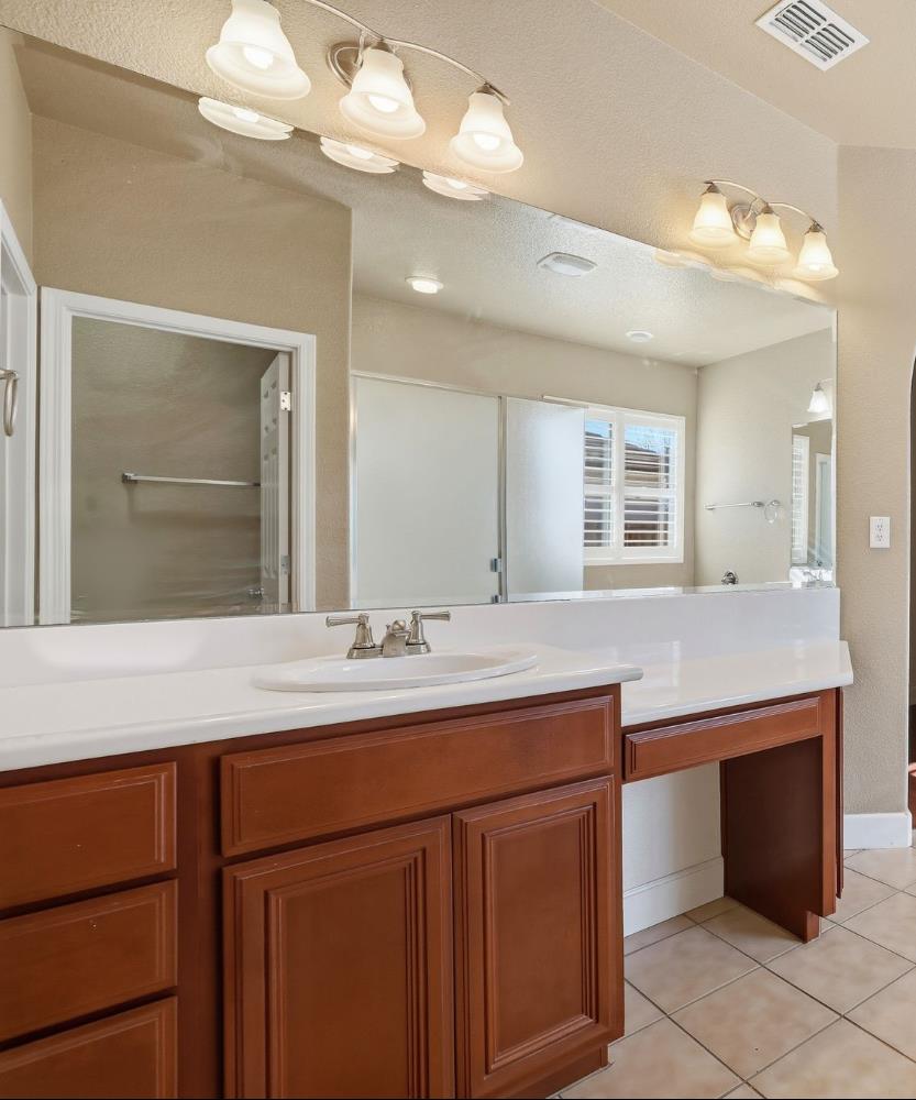 1730 Tasca Lane Manteca, CA 95337 - Photo 56 of 83 a bathroom with a sink a vanity and a large mirror