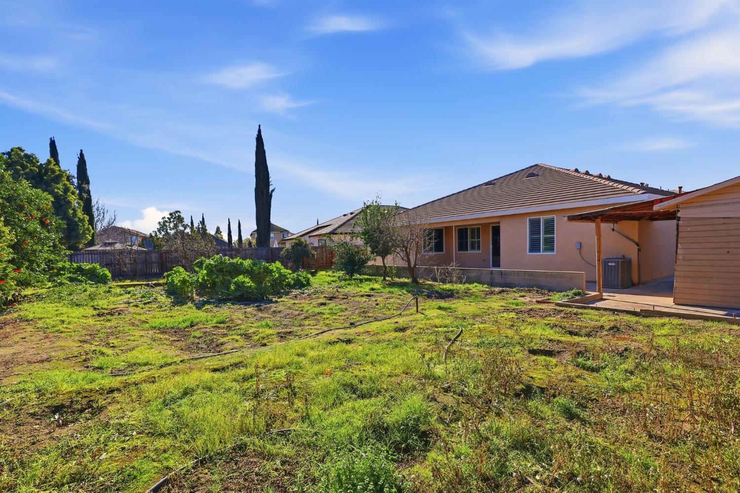 1730 Tasca Lane Manteca, CA 95337 - Photo 69 of 83 a yellow house with trees in front of it