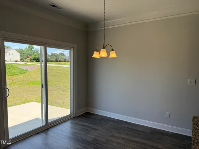 a view of an empty room with a window and fireplace