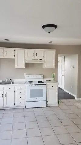 a view of a room with a fireplace and a chandelier fan