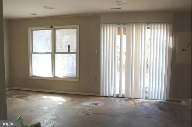 an empty room with windows and closet