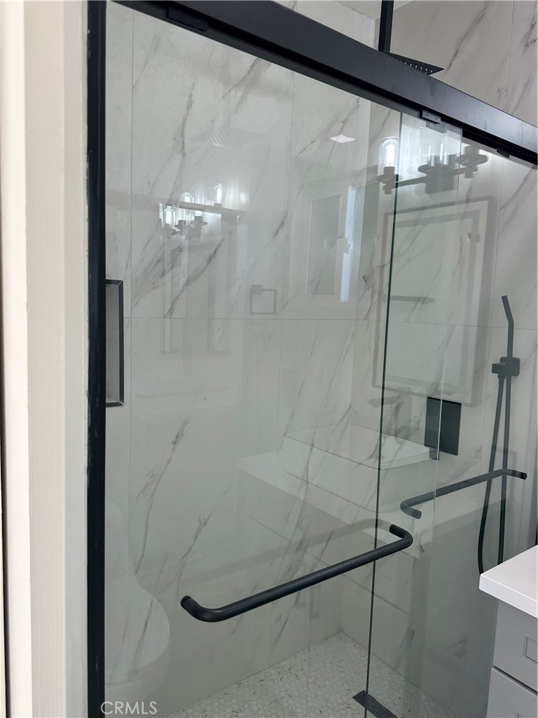 19140 Strathern Street Reseda, CA 91335 - Photo 19 of 33 a bathroom with a glass shower door