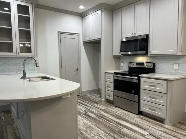 a kitchen with stainless steel appliances a stove microwave and sink