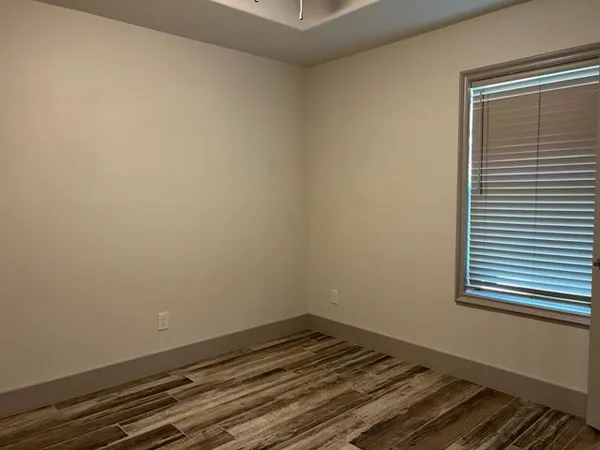 a view of a room with wooden floor and a window