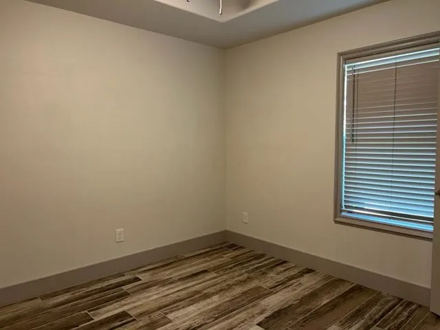 a view of a room with wooden floor and a window