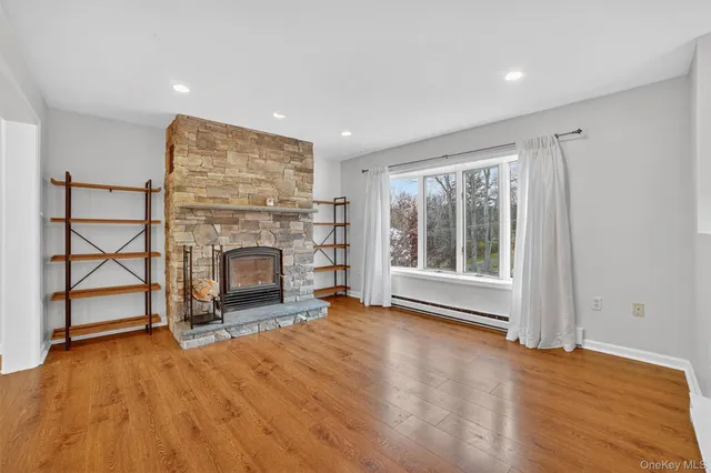 a view of an empty room with a fireplace and a window