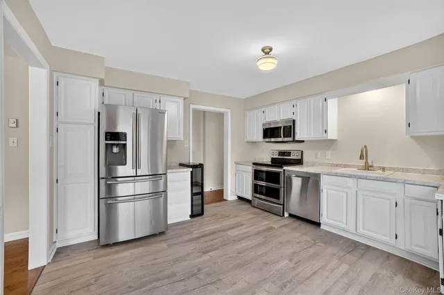 a kitchen with cabinets stainless steel appliances and wooden floor