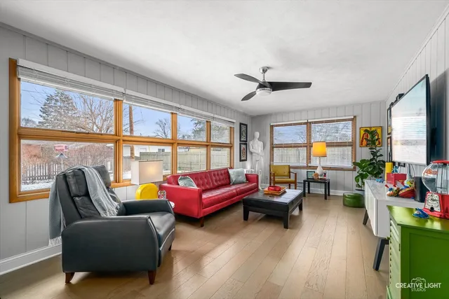 a living room with furniture a flat screen tv and a large window