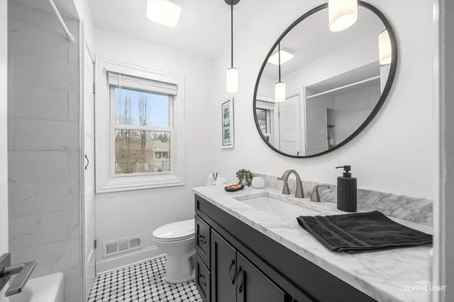 a bathroom with a sink a toilet and a mirror