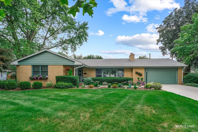 a front view of a house with a yard and potted plants
