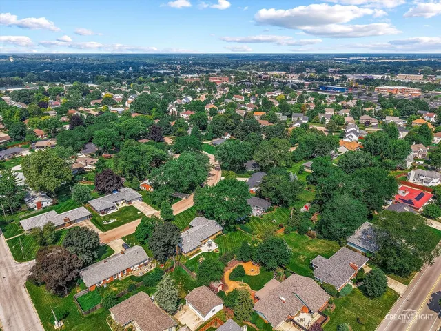 an aerial view of residential houses with outdoor space and trees