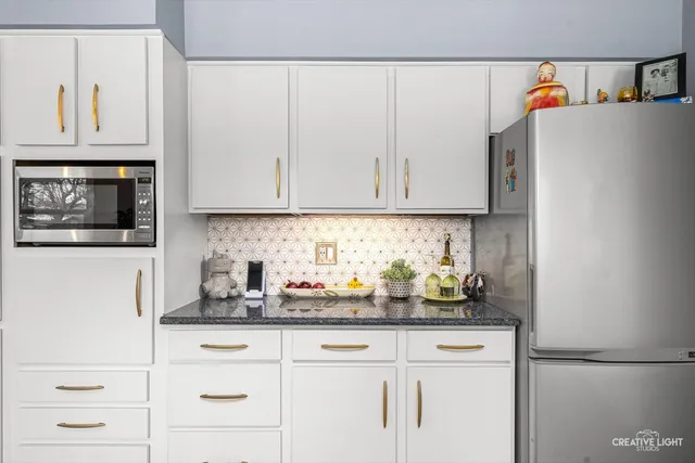 a kitchen with stainless steel appliances white cabinets and a refrigerator