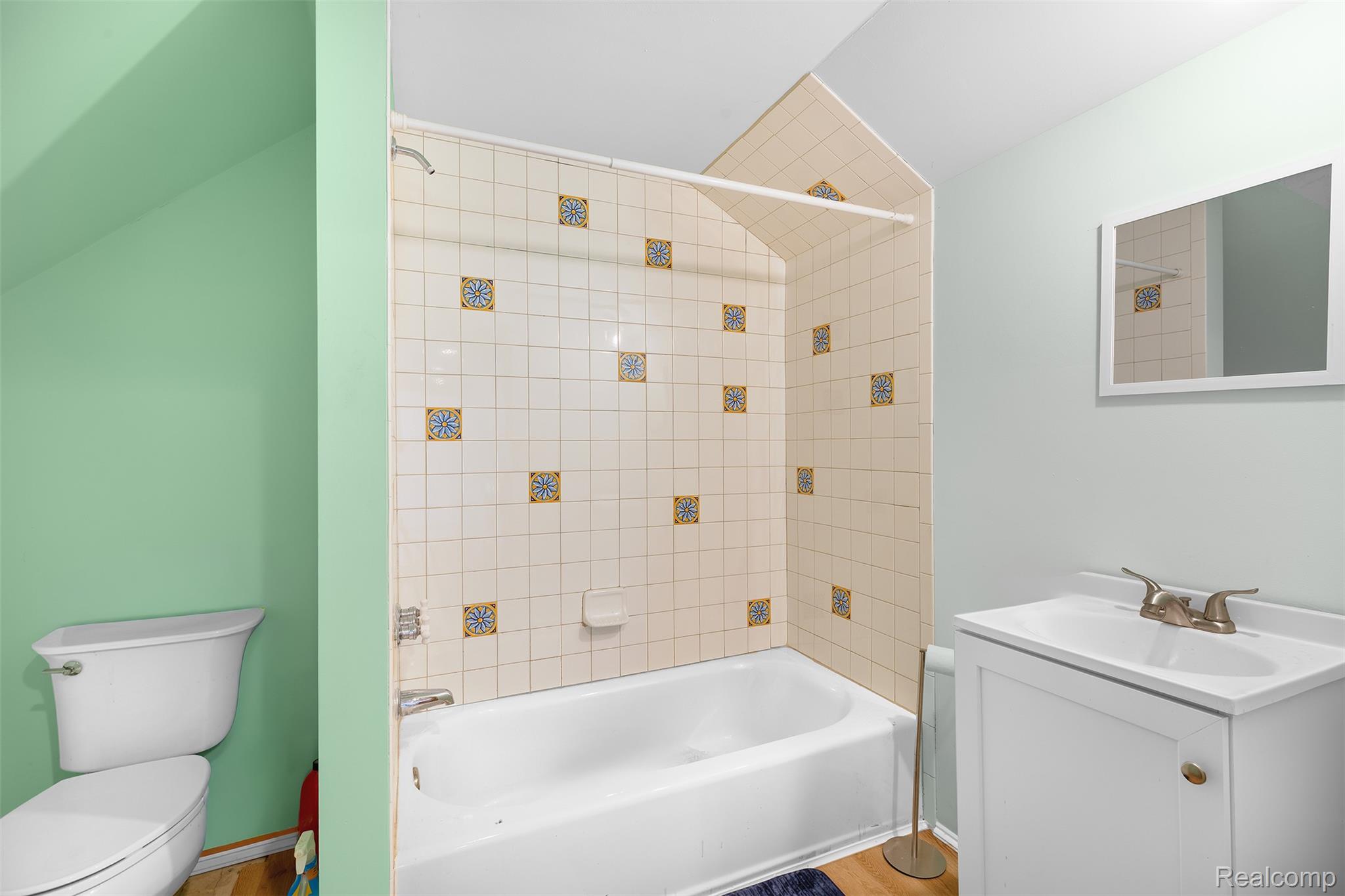 27901 Brandes Road Flat Rock, MI 48134 - Photo 21 of 38 Bathroom featuring a white bathtub, ceramic tile surround with decorative accents, a white vanity with integrated sink, and a framed wall mirror
