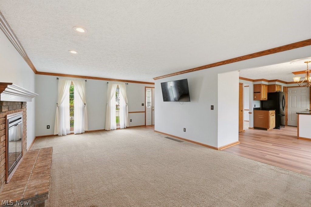 5321 Young Road Stow, OH 44224 - Photo 9 of 37 Carpeted living space featuring a brick fireplace with a white mantel, two large windows, wood trim, and recessed lighting