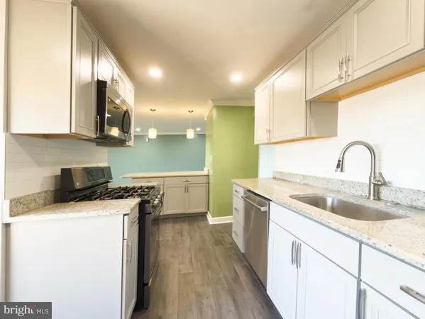 a kitchen with a sink a stove and cabinets