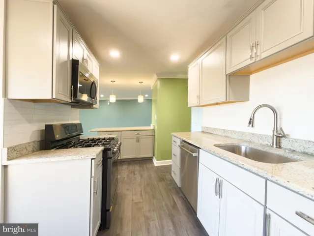 a kitchen with a sink a stove and cabinets