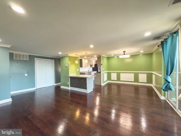 a view of a kitchen with wooden floor and a window