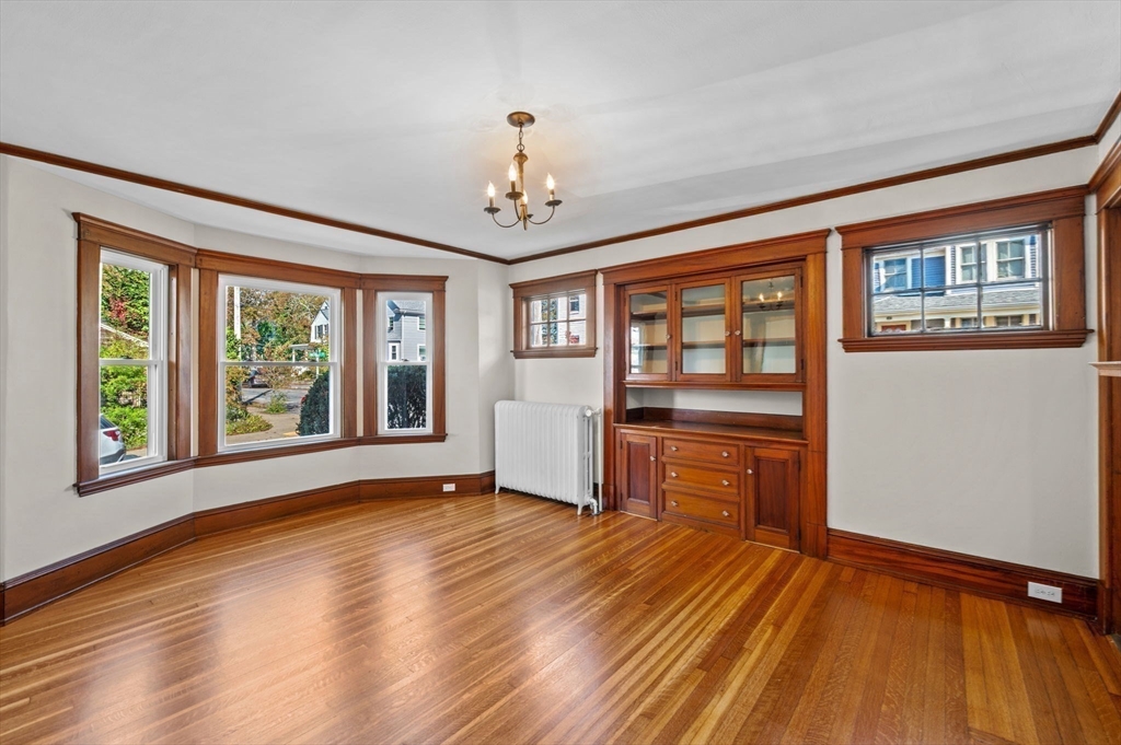 59 Butman Street, Unit 1 Beverly, MA 01915 - Photo 12 of 42 a view of an empty room with a window and wooden floor