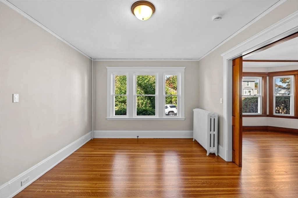 59 Butman Street, Unit 1 Beverly, MA 01915 - Photo 20 of 42 a view of an empty room with wooden floor and a window