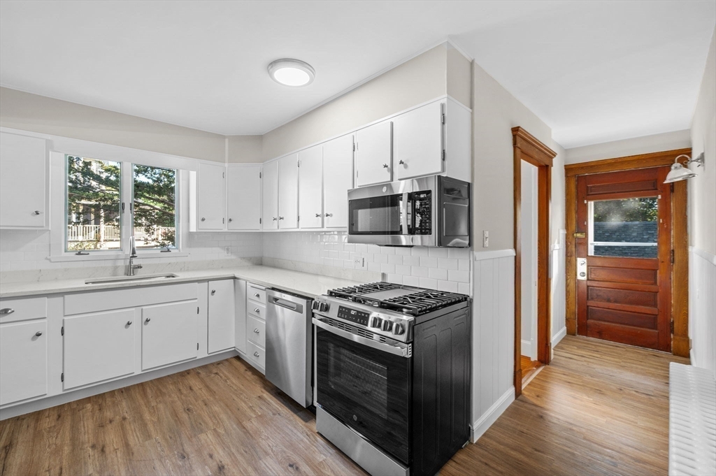 59 Butman Street, Unit 1 Beverly, MA 01915 - Photo 24 of 42 a kitchen with stainless steel appliances white cabinets a sink and a stove