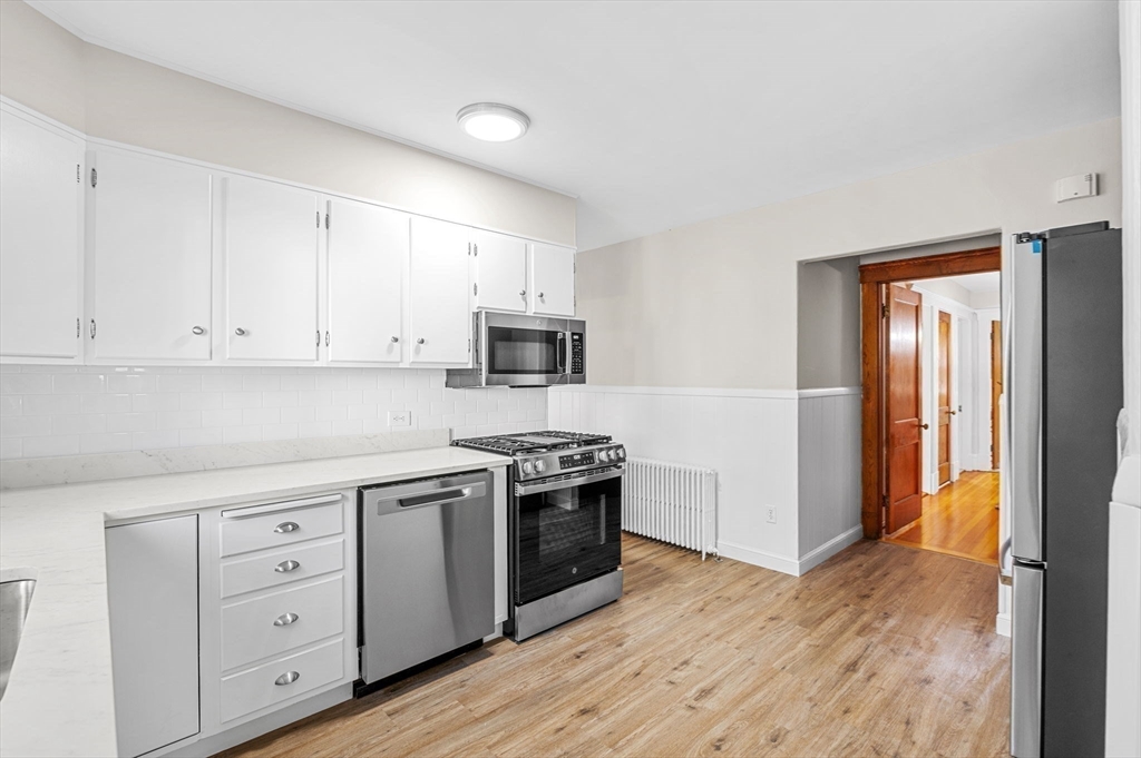 59 Butman Street, Unit 1 Beverly, MA 01915 - Photo 27 of 42 a kitchen with white cabinets and stainless steel appliances