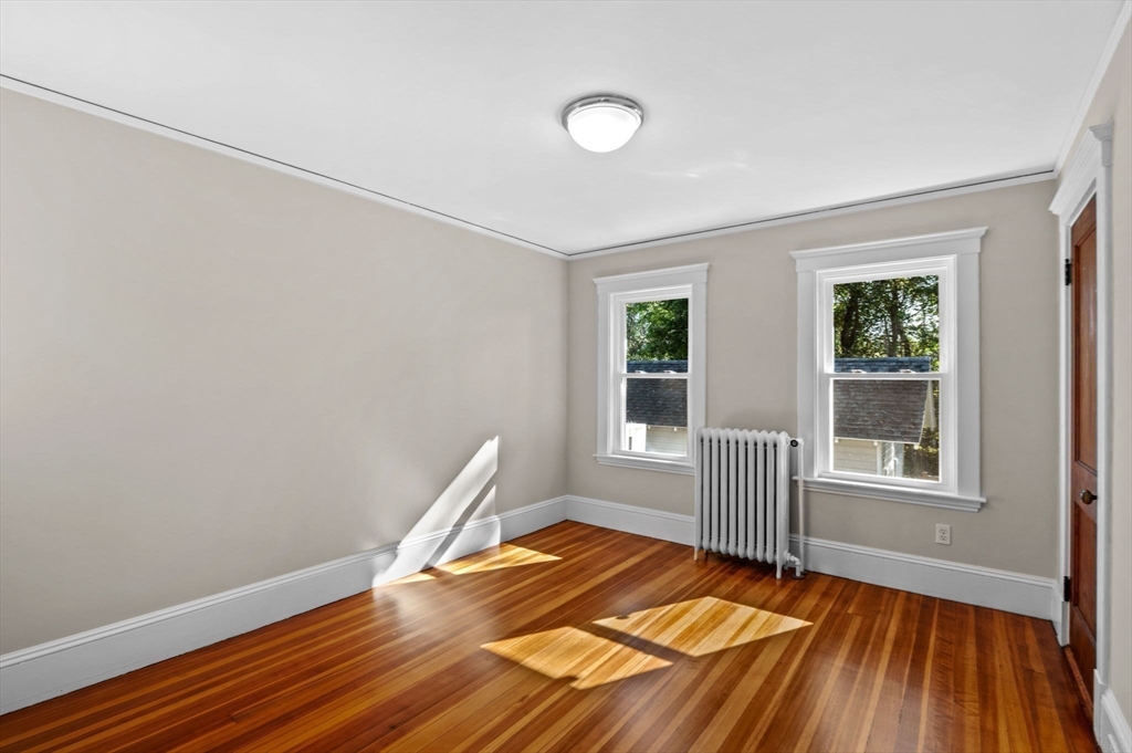59 Butman Street, Unit 1 Beverly, MA 01915 - Photo 30 of 42 an empty room with wooden floor and windows