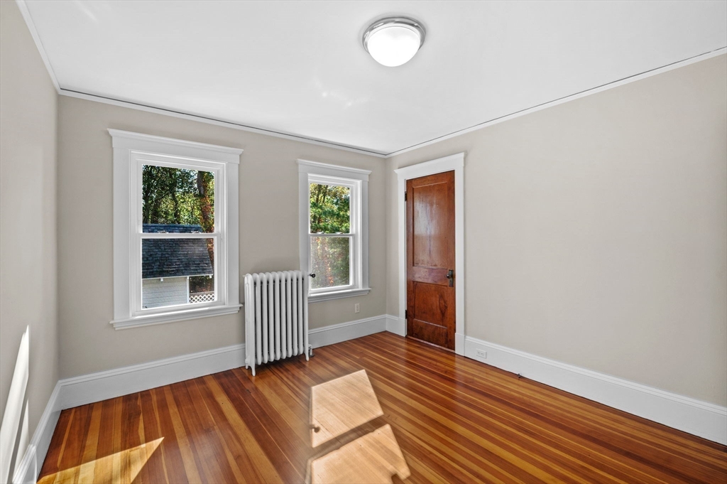 59 Butman Street, Unit 1 Beverly, MA 01915 - Photo 31 of 42 an empty room with wooden floor and windows