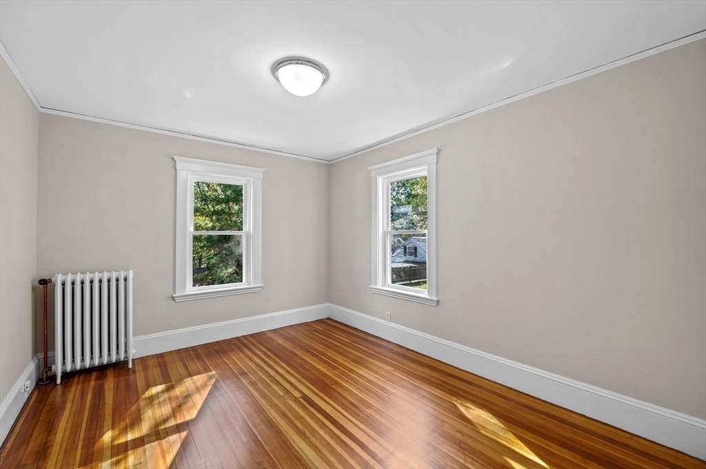 59 Butman Street, Unit 1 Beverly, MA 01915 - Photo 33 of 42 an empty room with wooden floor and windows