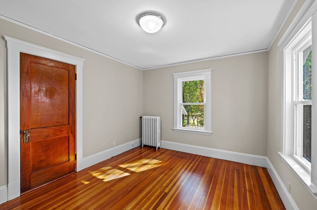 59 Butman Street, Unit 1 Beverly, MA 01915 - Photo 34 of 42 an empty room with window and wooden floor