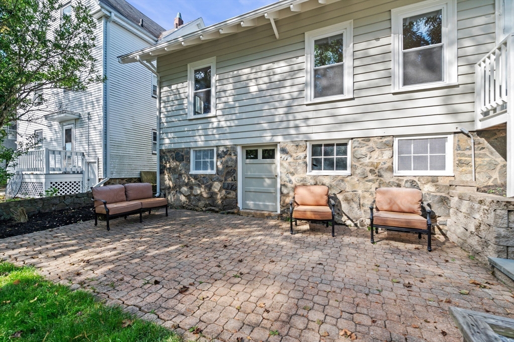 59 Butman Street, Unit 1 Beverly, MA 01915 - Photo 41 of 42 a backyard of a house with barbeque oven table and chairs