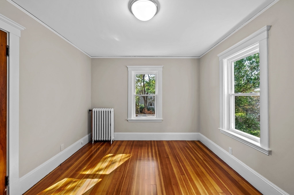 59 Butman Street, Unit 1 Beverly, MA 01915 - Photo 9 of 42 a view of empty room with wooden floor and fan