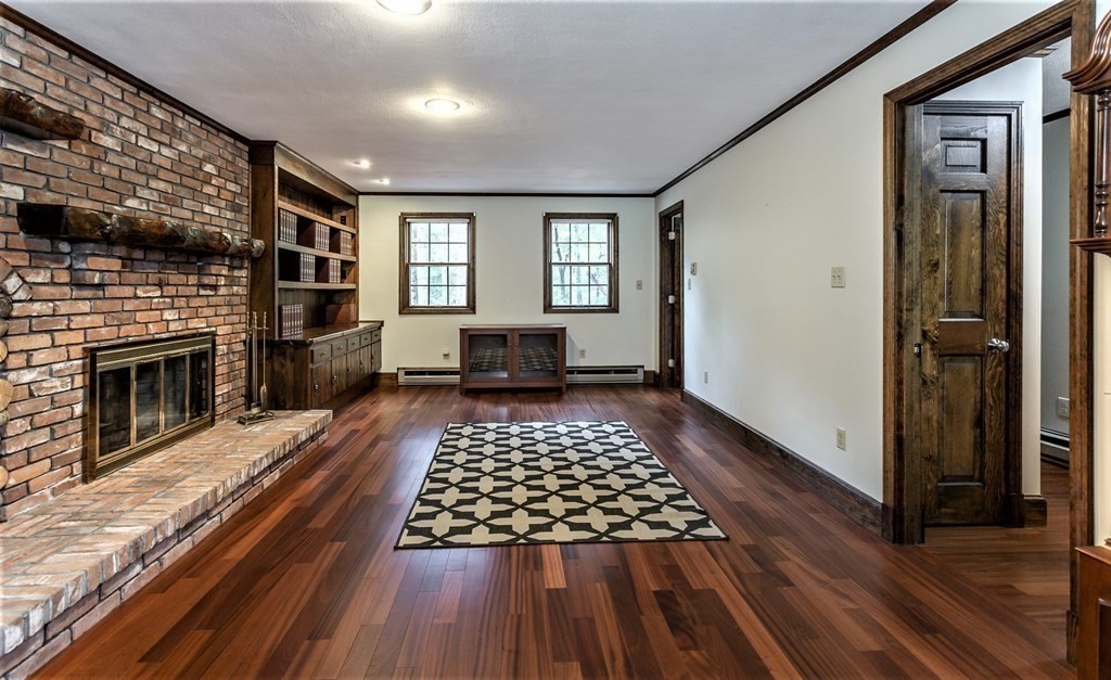 591 Neck Road Rochester, MA 02770 - Photo 17 of 32 a view of a livingroom with wooden floor and a fireplace