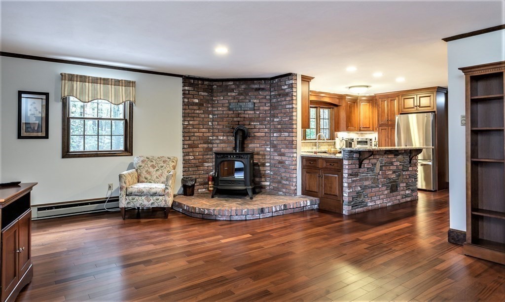 591 Neck Road Rochester, MA 02770 - Photo 10 of 32 a living room with fireplace furniture and a wooden floor