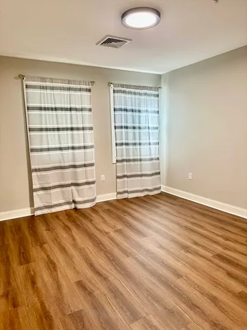 a view of walk in closet with wooden floor