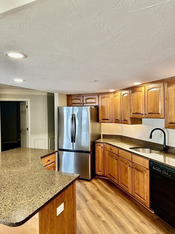 5 Mission Road, Unit 101 Chelmsford, MA 01863 - Photo 4 of 18 a kitchen with stainless steel appliances granite countertop a sink and a refrigerator